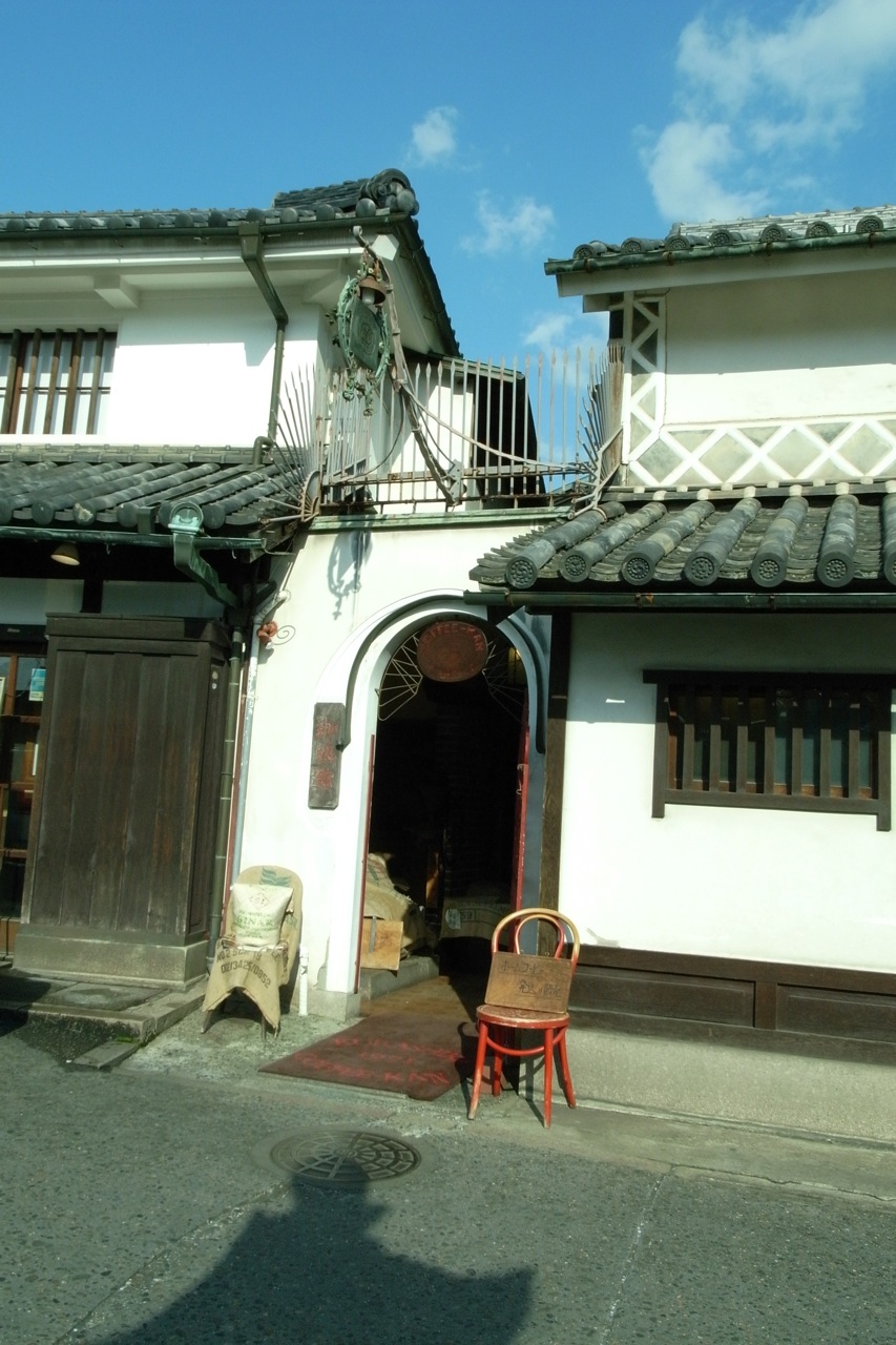 倉敷珈琲館の白壁と瓦屋根、入り口の前に置かれた椅子
