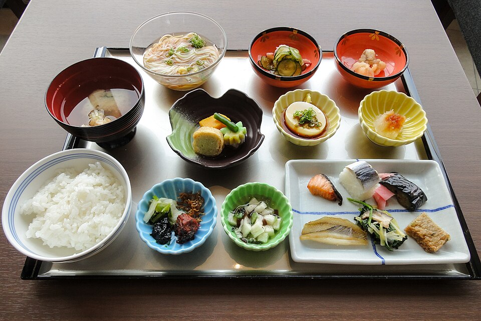 ご飯、魚、卵焼き、小鉢などをトレーに並べた2015年の朝食