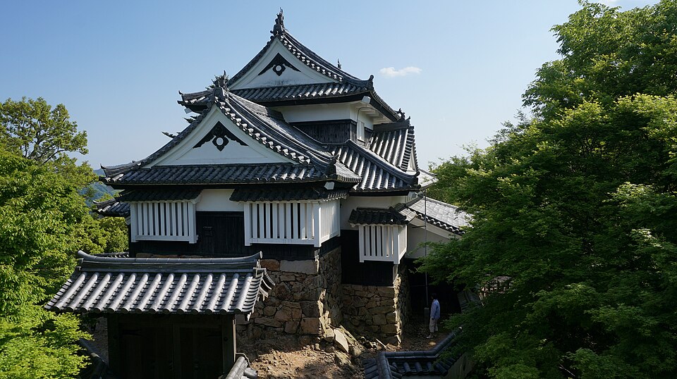 樹木に囲まれた備中松山城の天守を二重櫓から見る