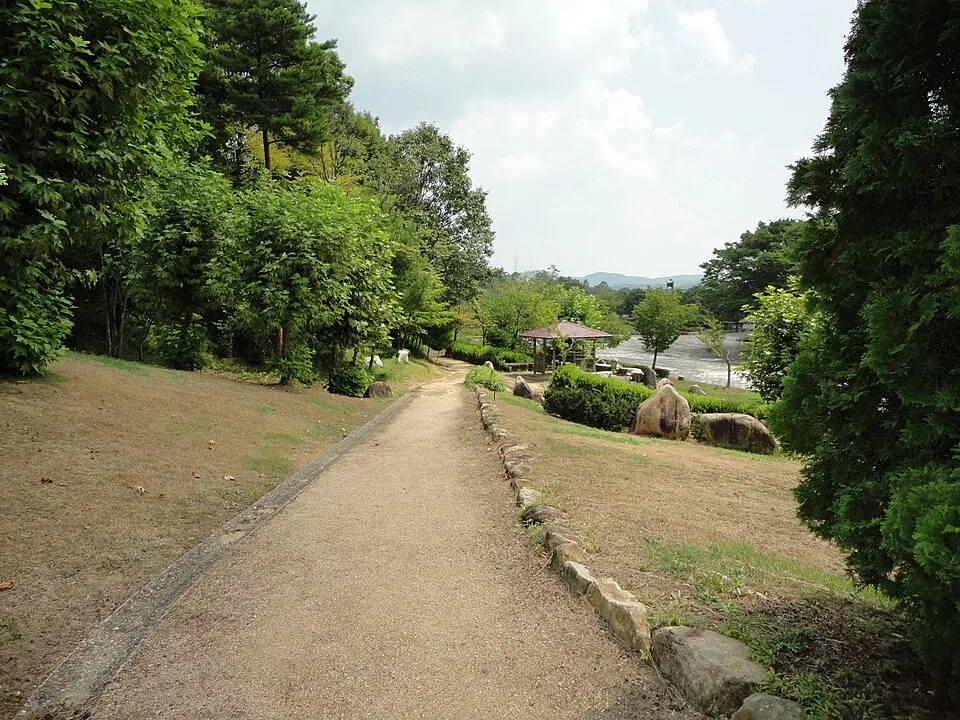 吉備中央公園の木々に囲まれた下りの遊歩道と、その先にあるあずまや。2010年8月25日の記録。