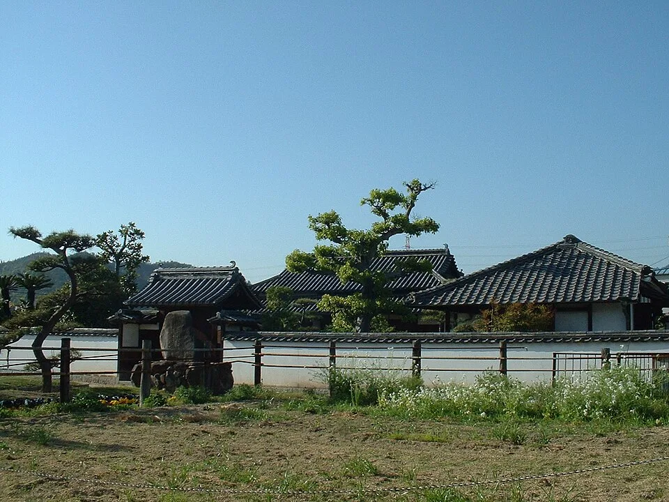 瓦屋根と白い塀に囲まれた仁科芳雄博士生家の外観