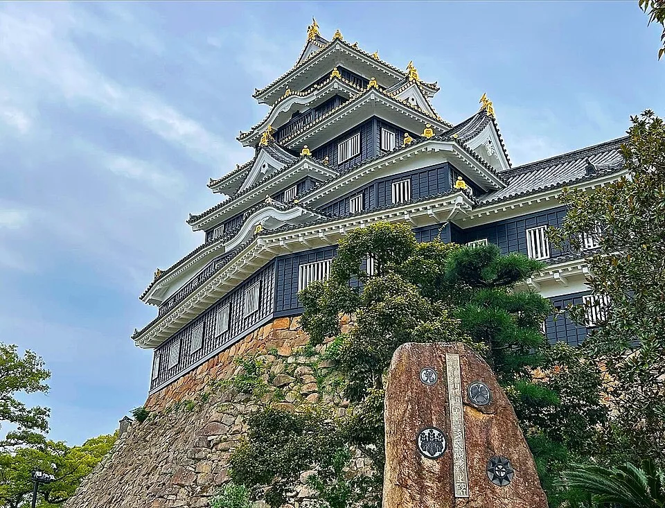 岡山城の黒い天守と周囲の石垣、木々（2023年撮影）