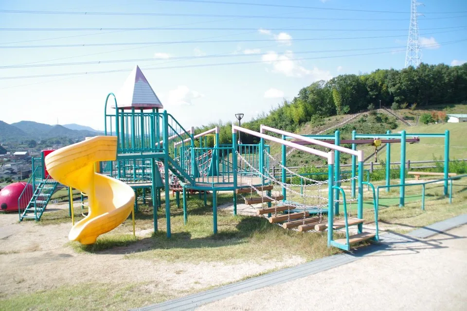 つばきの丘運動公園の黄色い滑り台と橋を備えた複合遊具（2017年）