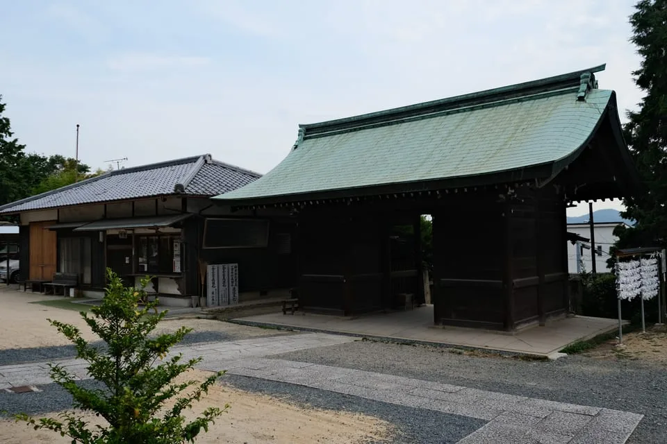 境内側から見た鶴崎神社の木造の随神門と、隣の建物。