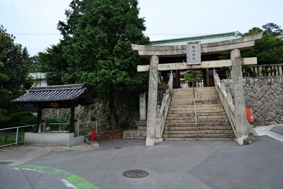 石段の下から見上げる鶴崎神社の鳥居。奥に随神門が見える。