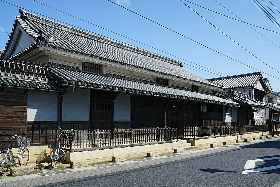 白壁と格子、瓦屋根が並ぶ旧矢掛脇本陣髙草家住宅